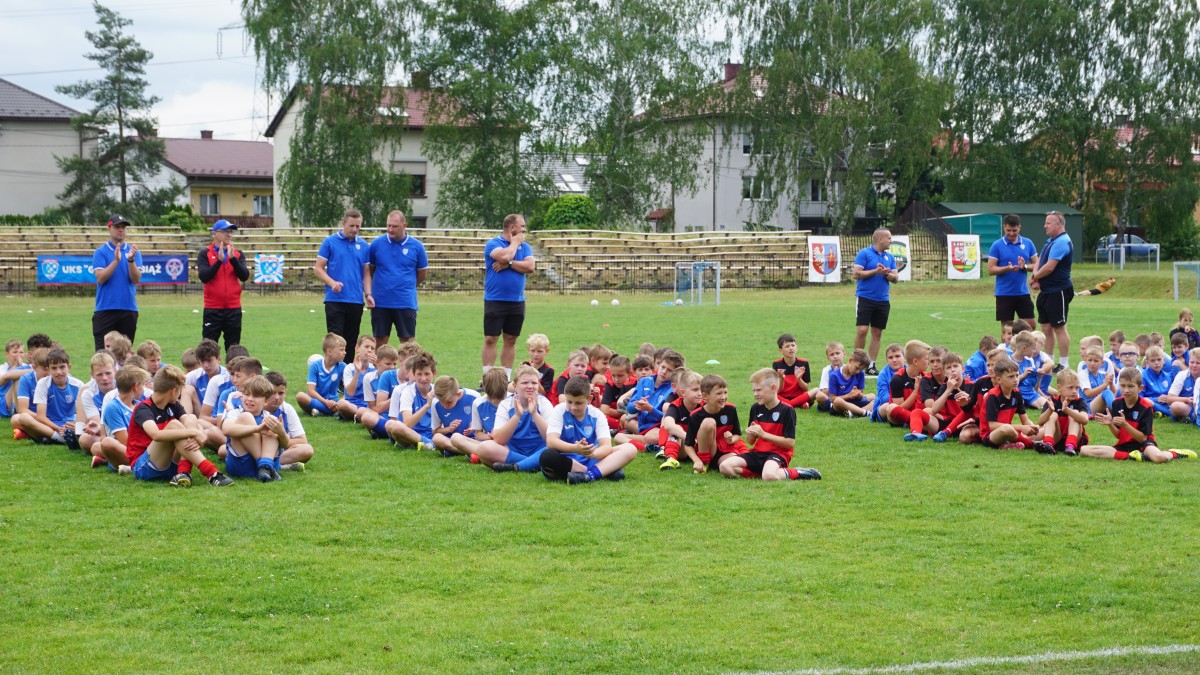 Młodsi zawodnicy Górnik Libiąż siedzą na murawie 