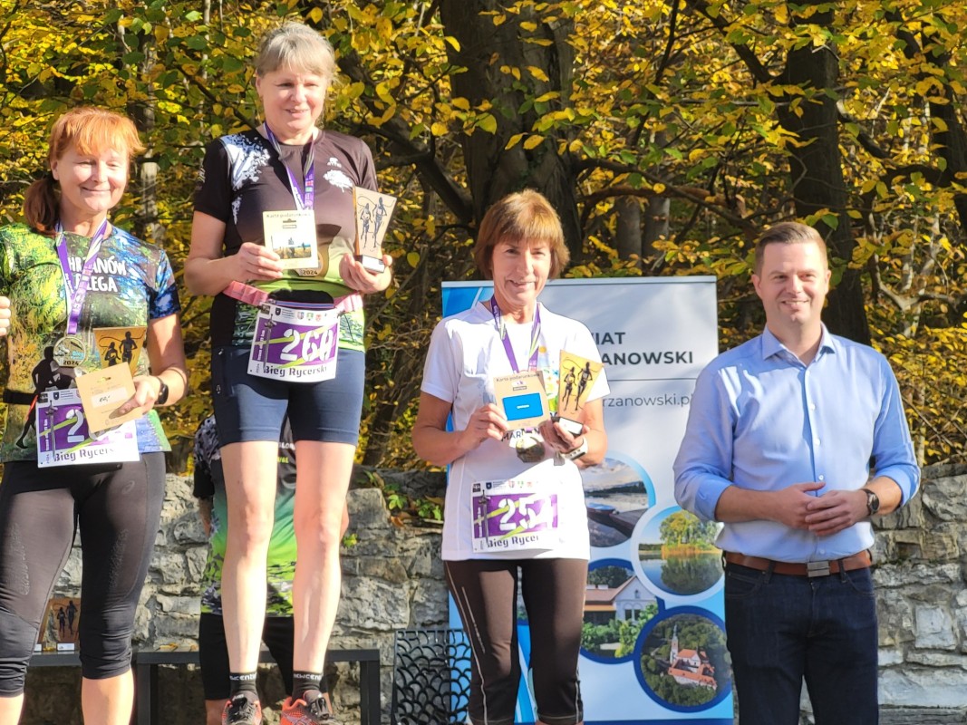 Zdjęcie 3 zawodniczek na podium wraz ze starostą.