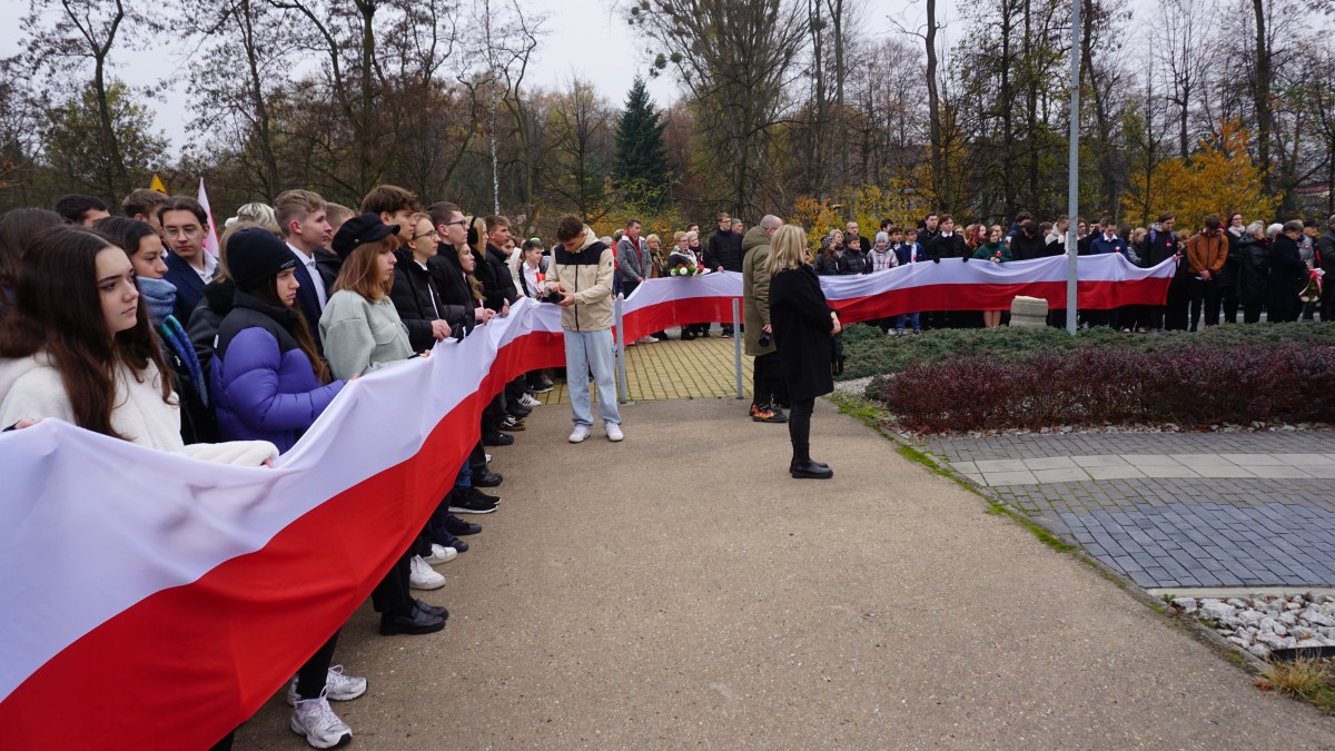 Młodzież trzyma długą flagę biało-czerwoną