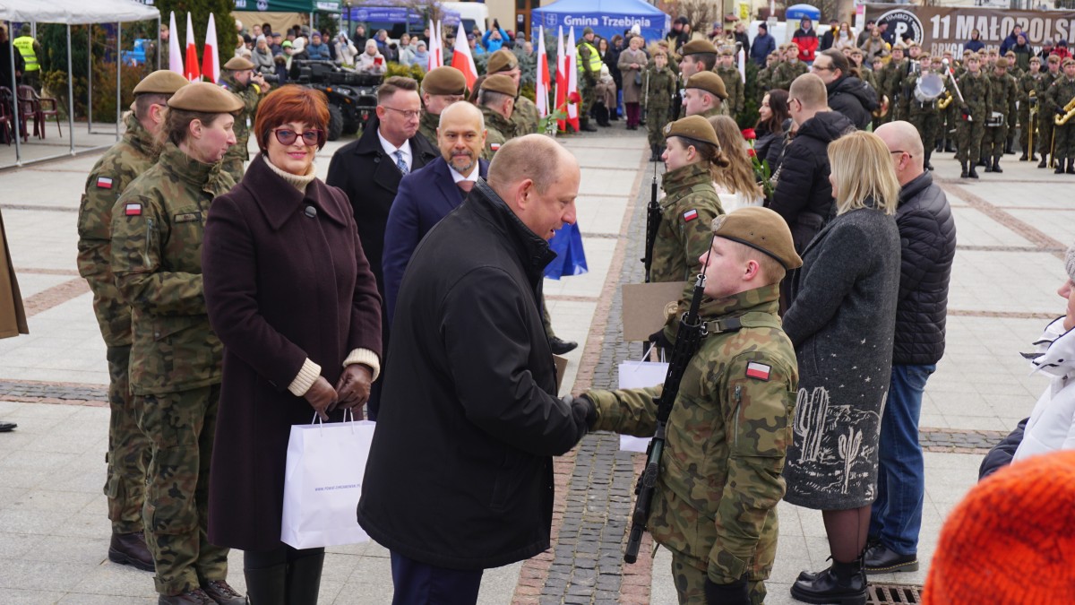 Zdjęcie przedstawicieli władz państwowych i samorządowych, którzy składają gratulacje wyróżnionym żołnierzom-rekrutom i ich rodziom.