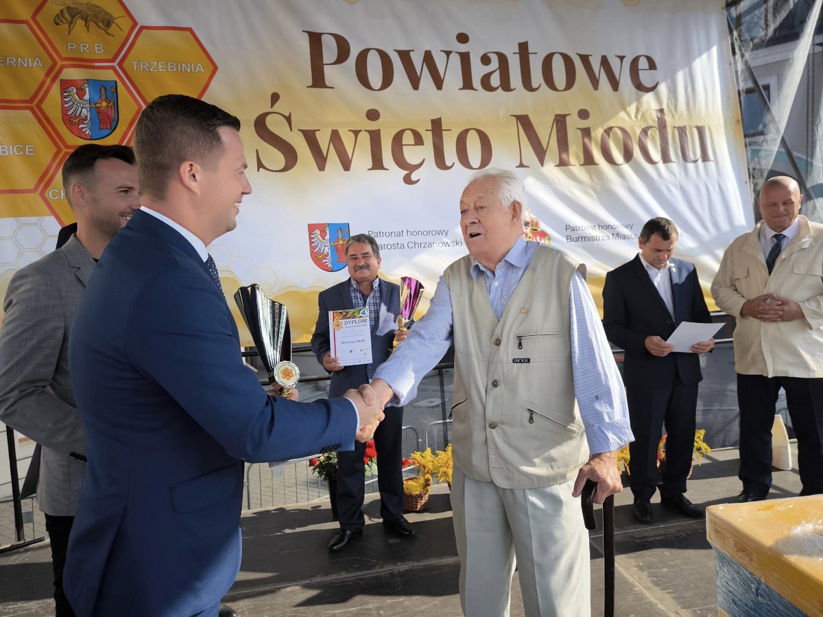 Mężczyzna w garniturze podaję rękę starszemu mężczyźnie 