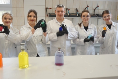 Uczniowie w fartuchach w laboratorium chemicznym